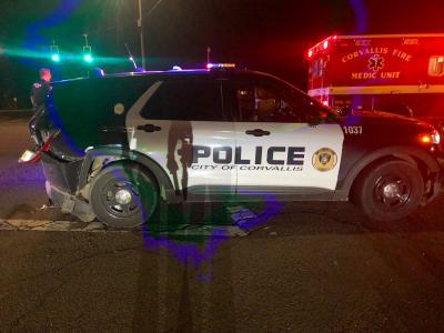 Corvallis Police Department patrol vehicle with moderate-to-severe rear end damage at night