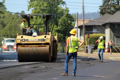 Foreman standing in front of an asphalt smoother.