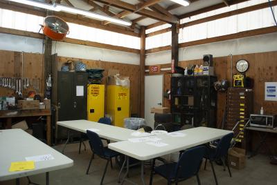 Cramped employee breakroom piled with storage and hazardous materials