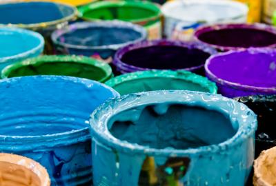 Paint buckets with dried paint in blue, teal, purple colors.