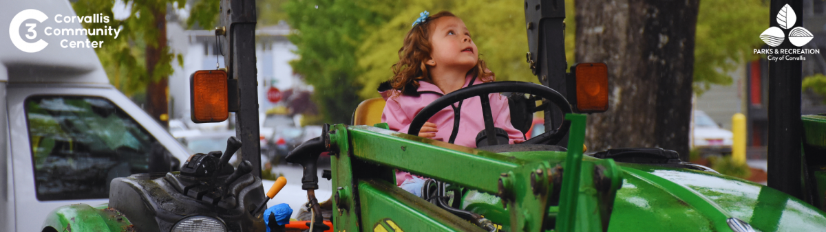 A girl sitting on a John Deere tractor. 