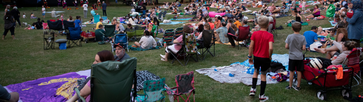 Kids and families at a concert in the park.