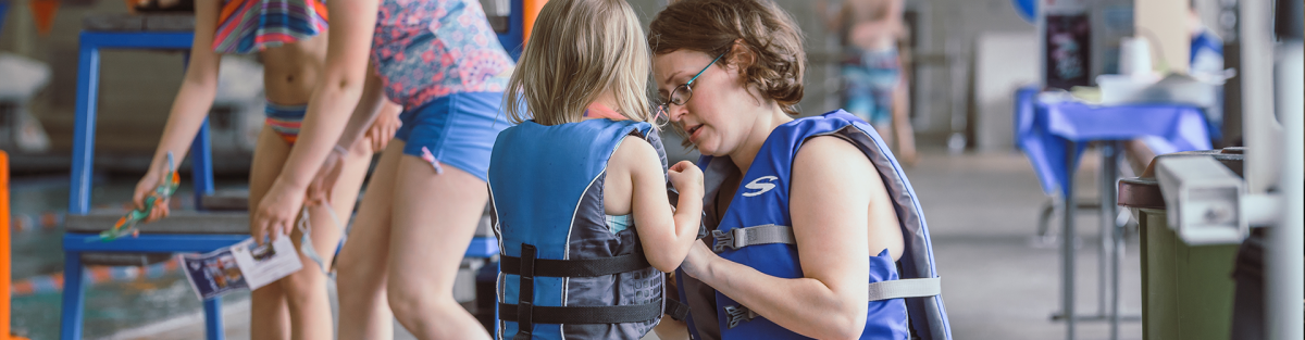 mom putting life jacket on toddler at osborn