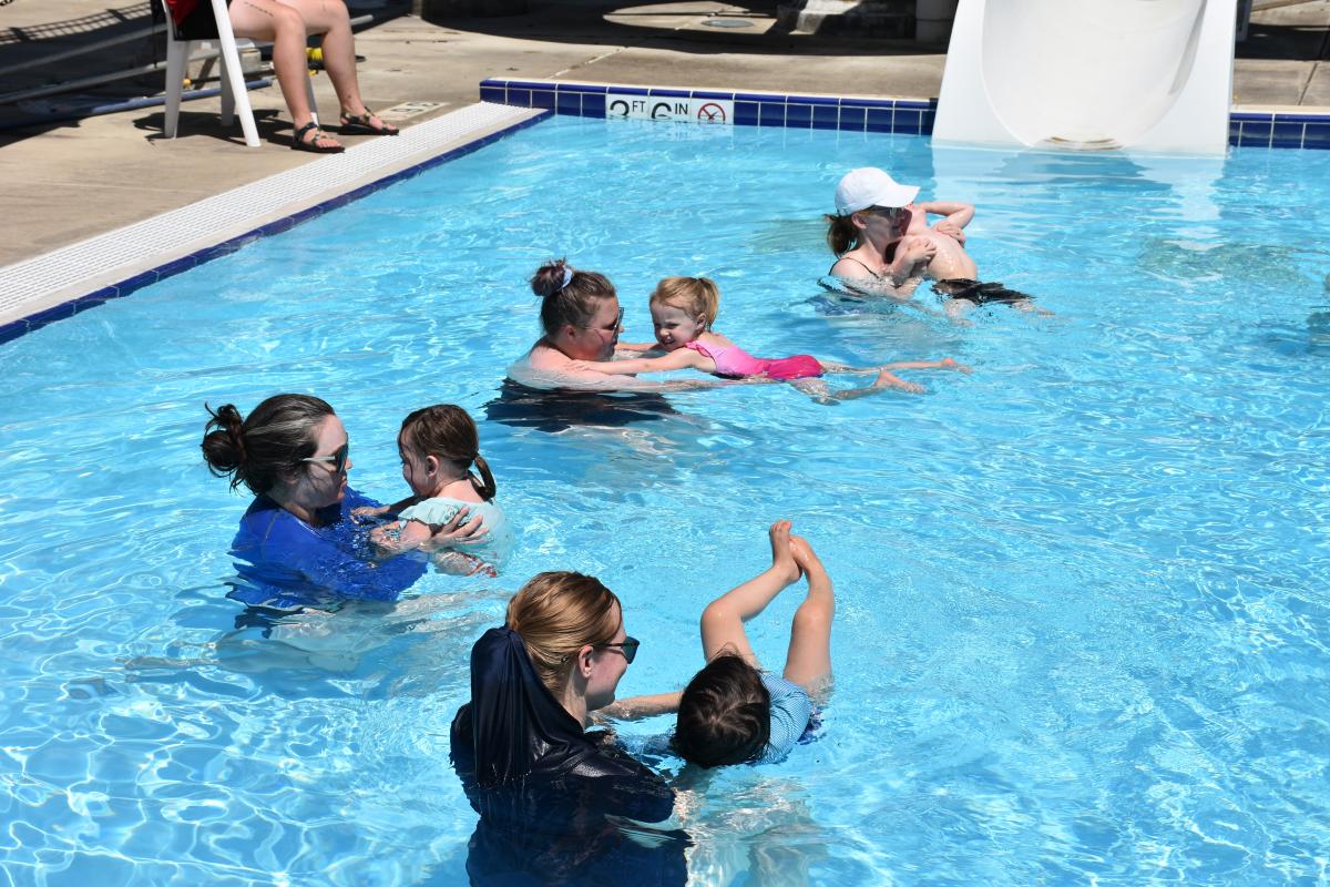 Toddler Time Toddlers and their parents playing in an outdoor pool.
