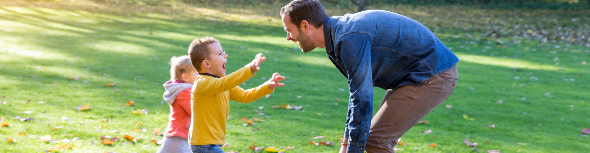 young kids excitedly running to dad in park