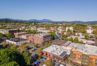 Downtown Corvallis Downtown Corvallis skyline with buildings and trees against a brilliant blue sky.