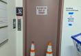 Elevator with an out of service sign and two orange hazard cones blocking the door