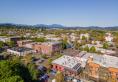 Downtown Corvallis skyline with buildings and trees against a brilliant blue sky.