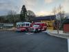Fire Station 2 exterior shot showing trees in the background and a fire engine and ambulance parked in the parking lot